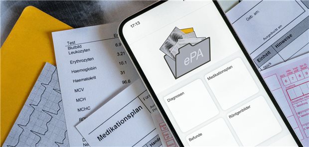 Ein Smartphone auf dem gerade eine elektronische Patientenakte angezeigt wird, liegt auf medizinischen Dokumenten, horizontal