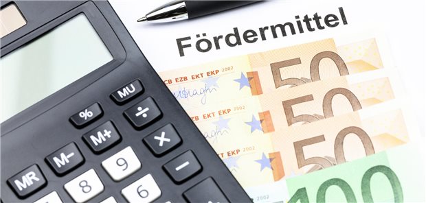 Taschenrechner und Stift auf Geldscheinen.