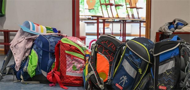 Schulranzen stehen vor einem Klassenzimmer.