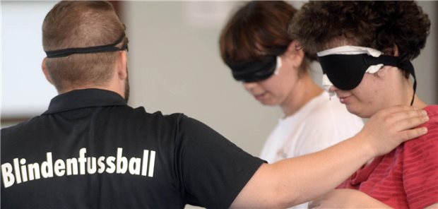 Ophthalmologen wollen Sportangebote für Blinde und Sehbehinderte stärken Menschen mit Augenbinden bereiten sich auf ein Spiel vor. Eine Person trägt ein T-Shirt mit der Aufschrift: "Blindenfußball"