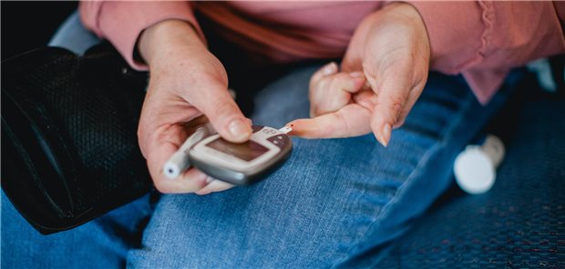 Ein Mensch sticht sich in den Finger und macht einen Blutzuckertest.
