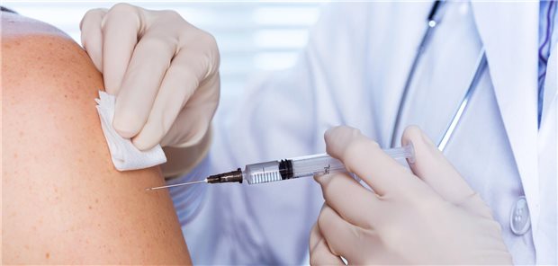 Arzt impft Patientin.