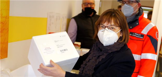 Zunächst keine weiteren Corona-Impfdosen für Brandenburg Brandenburgs Gesundheitsministerin Ursula Nonnemacher (Bündnis 90/Die Grünen), hält vor der ersten Corona-Impfung im Bundesland im DRK-Seniorenwohnpark Großräschen eine Box mit dem Impfstoff. Auf die nächste Lieferung muss aber noch ein bisschen gewartet werden. (Archivfoto)