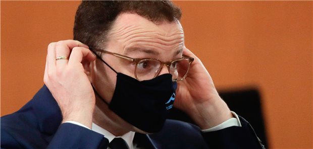 Spahn arbeitet trotz Infektion im Homeoffice Bundesgesundheitsminister Jens Spahn (CDU) richtet seinen Mund-Nasen-Schutz am Mittwoch während einer Sitzung des Bundeskabinetts.
