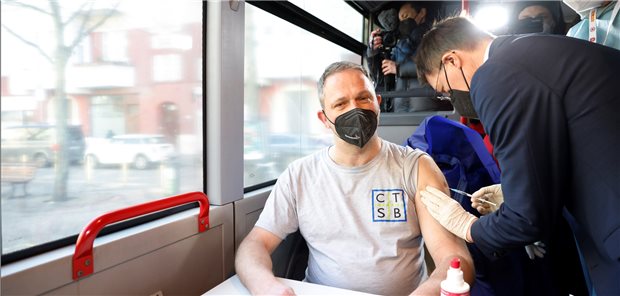 COVID-19: Wie Unentschlossene durch einen Impf-Bus überzeugt werden sollen Bundesgesundheitsminister Karl Lauterbach (SPD) impft einen Mann im Tour-Bus der Initiative #ImpfenHilft in Berlin-Neukölln.