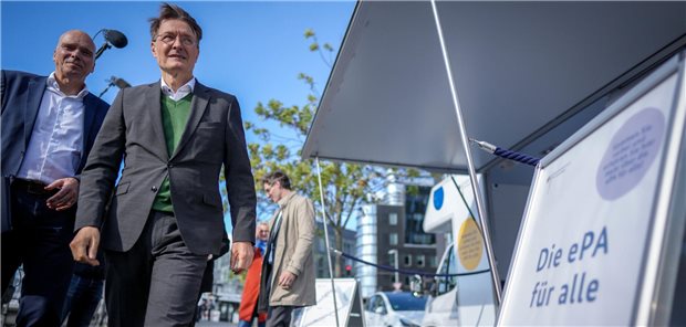 Bundesgesundheitsminister Lauterbach steht an einem Infomobil.