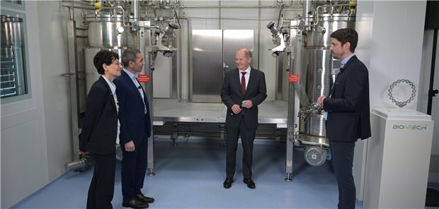 Kanzler Scholz will bei Forschungsförderung Gas geben Bundeskanzler Olaf Scholz (SPD, 2. v.r.) wird von den BioNTech-Gründern Ugur Sahin (2.v.l) und Özlem Türeci am Standort in Marburg durch die Produktion geführt. Scholz wollte sich am Donnerstag über den Bau der ersten unternehmenseigenen Plasmid-DNA-Produktion am Standort Marburg informieren.