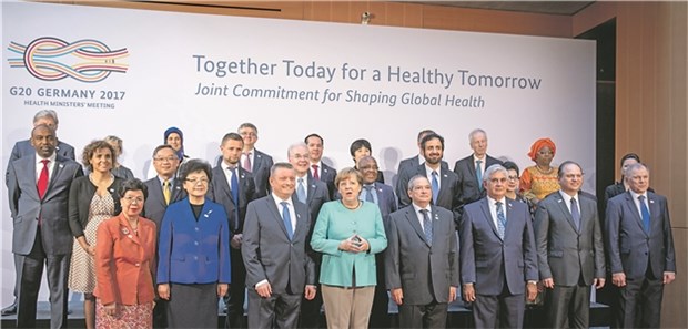 G20 muss am Krisenmanagement feilen Bundeskanzlerin Angela Merkel stellt sich mit Bundesgesundheitsminister Hermann Gröhe (CDU) zum Familienfoto beim G20-Gesundheitsministertreffen in Berlin.