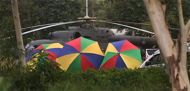 Das kommt auf die Geretteten im thailändischen Höhlendrama zu Bunte Schirme verhindern den Blick auf einen Helikopter, der die aus einer Höhle geretteten Jungen und ihren Trainer in ein Krankenhaus fliegt.