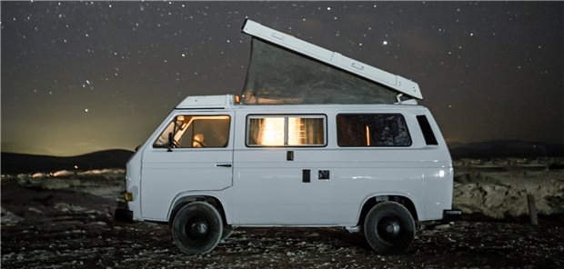 Camping-Bus unter den Sternen mit offenem Dach und Insektennetz.