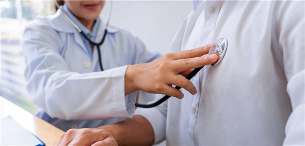 Eine Ärztin hört das Herz eines Patienten ab.