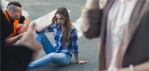 Conscious casualty of an accident sitting on the road with the emergency rescuer