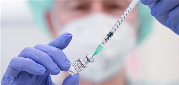 Ein Mitarbeiter des Klinikums Stuttgart bereitet in einer Impfstation eine Spritze für eine Impfung gegen das Coronavirus vor.