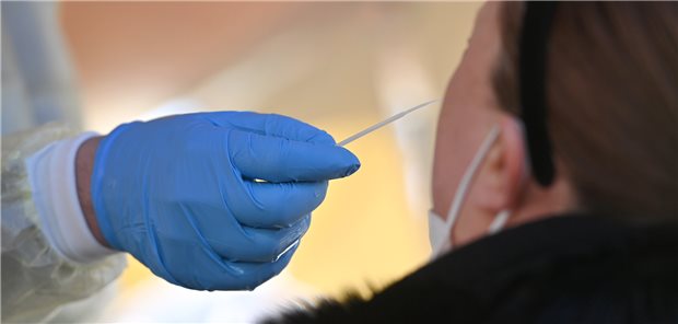 Corona-Test: Ein Tester nimmt einen Nasenabstrich.