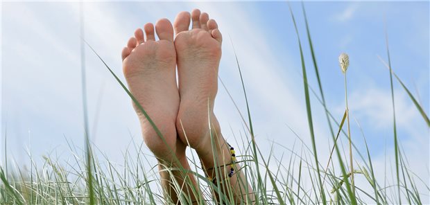 Initiative ermöglicht verarmten Krebspatienten Urlaub Füße im Gras - Symbolbild für Entspannung.