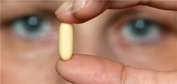 Mensch schaut sich Pille an.