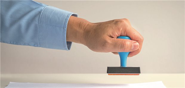Ein Mann hält einen Stempel in der Hand.