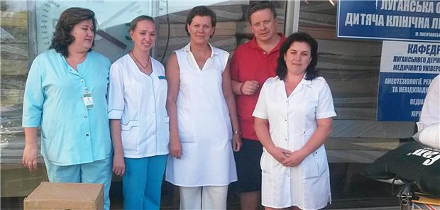 So hilft H.O.P.E. Ärzten bei der Behandlung schwer kranker Kinder in der Ukraine Das medizinische Personal des regionalen Kinderkrankenhauses von Lugansk mit dem Gründer von „HOPE. We help children“, Wolfgang Ponto (links), bei der Entgegennahme von medizinischen Hilfsgütern und Verbrauchsmaterialien im Jahr 2015.