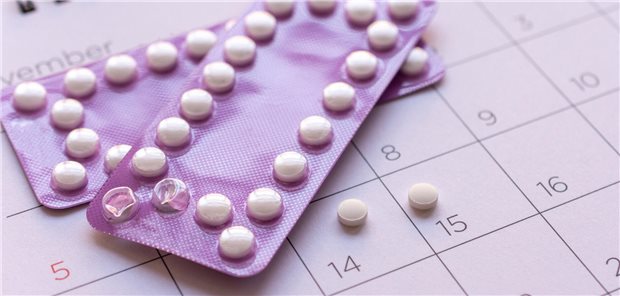 Hormonelles orales Verhütungsmittel in Plastikverpackunu auf der Monatübersicht eines Kalenders.