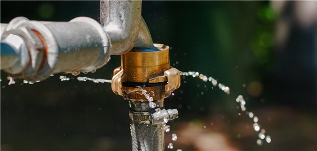 Ein undichter Wasserhahn aus dem Wasser schießt.