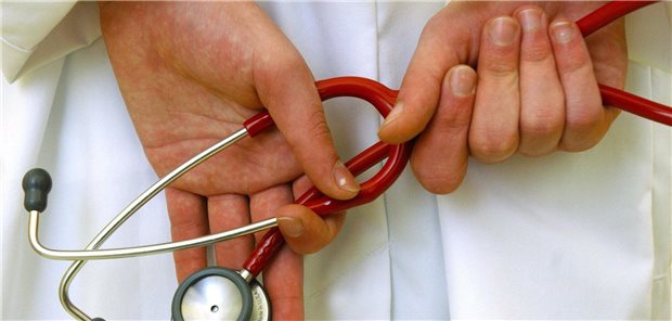 Ein Arzt hält ein Stethoskop in den Händen vor sich.