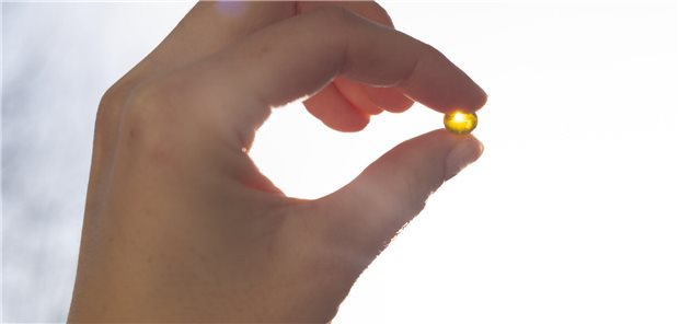 Vitamin-D-Supplementation schützt doch nicht vor Atemwegsinfekten Nahaufnahme einer Vitamin-D-Kapsel in der Hand eines Menschen die gegen das Sonnenlicht gehalten wird.