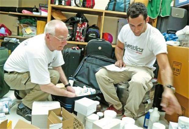 Der Arzt Wolfgang Riske aus Meinersen in Niedersachsen (links) packt in einem Lager in der Hafenstadt Rangun Medikamente aus.