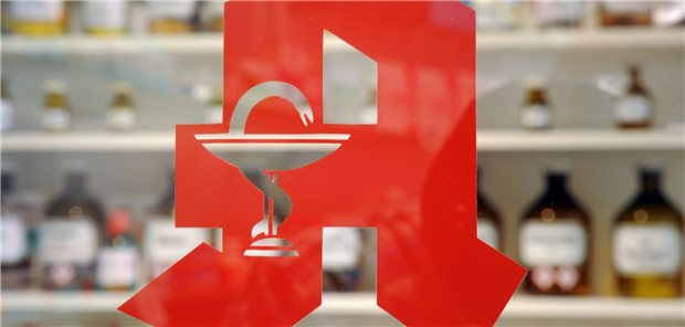 Das Foto zeigt das Logo an der Tür einer Apotheke.