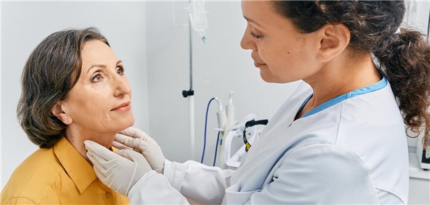 Eine Ärztin tastet den Hals einer Frau zur Diagnose von Schilddrüsenerkrankungen und Hypothyreose ab.