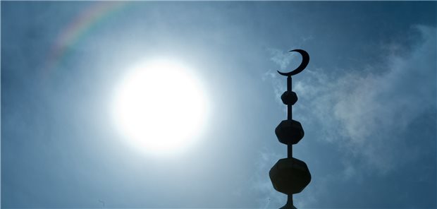 Ramadan beginnt – Cave bei chronisch Kranken! Der Halbmond auf dem Minarett der Abubakr Moschee in Frankfurt (Hessen) hebt sich als Schattenriss vor der Sonne ab. Nach Sonnenuntergang bis Sonnenaufgang dürfen Moslems auch während des Ramadan essen und trinken.