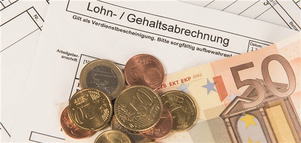 Gehaltszettel mit Münzen