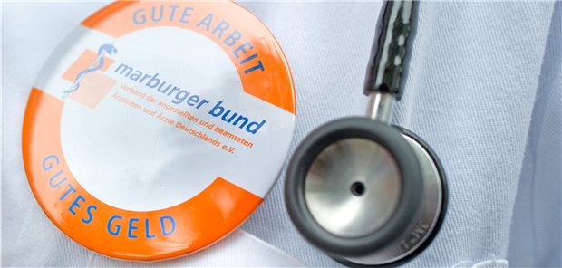 Marburger Bund legt Forderungen an die Wahlkämpfer vor Marburger-Bund-Pin auf einem Kittel neben Stethoskopkopf.