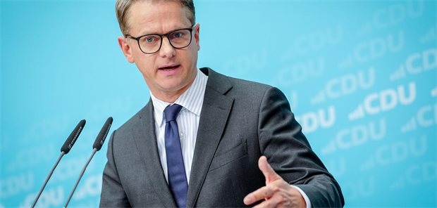 Carsten Linnemann steht vor einem Mikrofon und spricht.