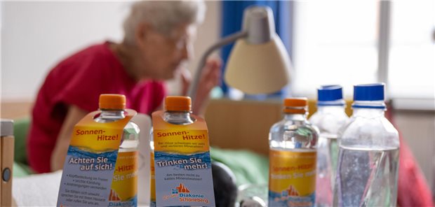Gesundheitsminister Lauterbach bereitet das Land auf einen heißen Sommer vor Wasserflaschen vor einer älteren Frau