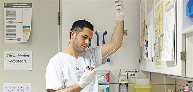 Heute anwerben, morgen pflegen? – So leicht ist es nicht! Der albanische Krankenpfleger Samed Qoshja bereitet in der Neurochirurgie der Charité am Campus Benjamin Franklin eine Infusion vor.