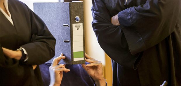 Der angeklagte Krankenpfleger sitzt im vergabgenen November mit einem Aktenordner vor dem Gesicht im Aachener Landgericht.