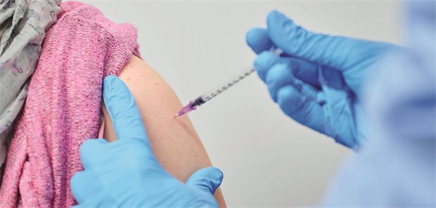 Arzt verabreicht eine Impfung an eine Patientin
