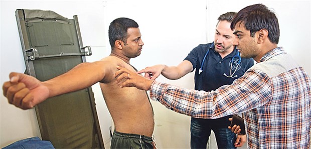 Ärztliche Hilfe aus den eigenen Reihen Der pakistanische Flüchtling Muhamad wird untersucht - der Arzt erhält dabeiUnterstützung von einem weiteren Flüchtling, der dolmetscht.