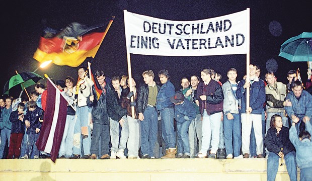 Der Eiserne Vorhang fällt, die Ärzte fliehen "Deutschland einig Vaterland": Berliner feiern auf der Mauer am Brandenburger Tor.