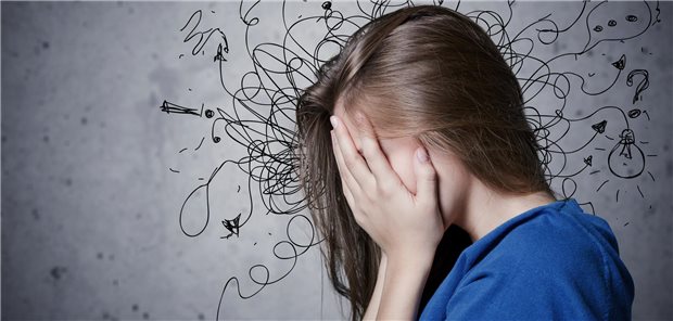 Ein Frau hat ihr gesicht in den Händen vergraben. Um ihren Kopf sind durcheinander-gehende Linien gezeigt, die ihre Verzweiflung symbolisieren sollen.
