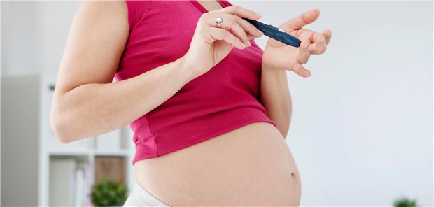 Schwangere Frau misst ihren Blutzucker. 