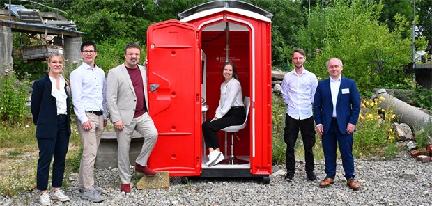 Das Forscherteam präsentiert die Praxis im Klohäuschen.