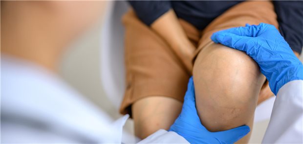 Arzt kontrolliert Knie.