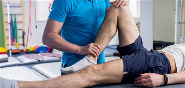Union für Teilakademisierung der Physiotherapeuten-Ausbildung Physiotherapeut behandelt das Bein eines Mannes