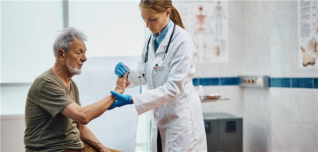 Eine Ärztin untersucht das Handgelenk eines älteren Patienten in einer medizinischen Klinik.