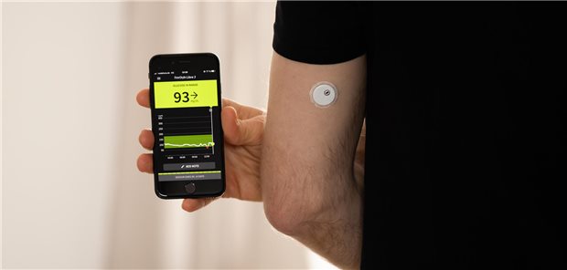 Mann hält Smartphone hoch.