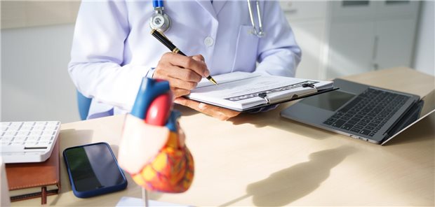 Ein Arzt arbeitet an einem Schreibtisch und analysiert Patientendaten zu kardiovaskulären Ereignissen. 