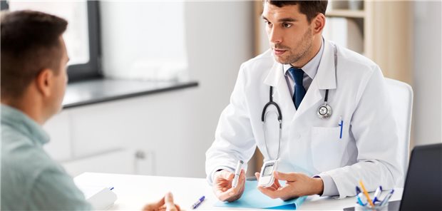 Arzt zeigt Patient etwas bei der Blutzucker-Messung.