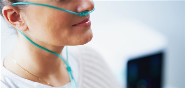 Frau erhält Sauerstoff per Schlauch.