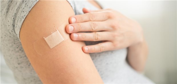 Nahaufnahme der Schulter einer schwangeren Frau nach der Impfstoffinjektion.